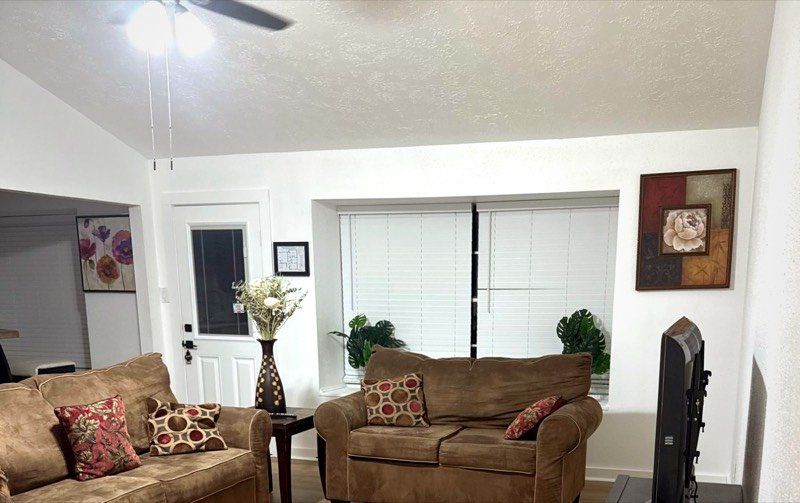 The living room at The Serenity Passage, with couches, plants and daylight through the blinds